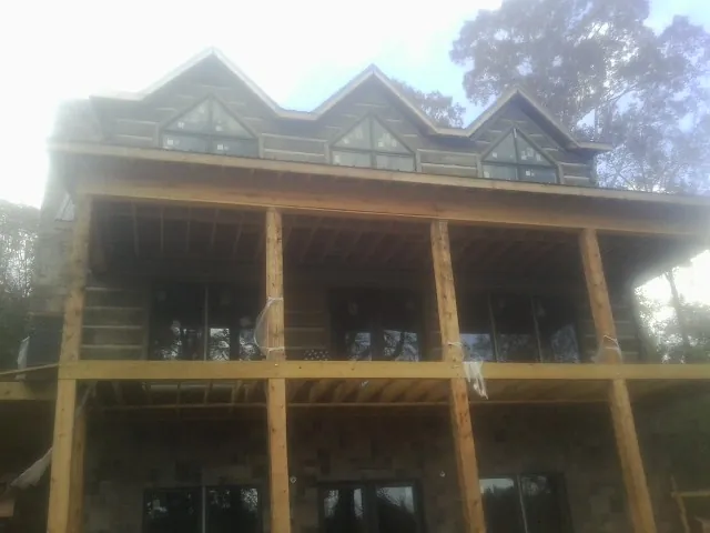 Dormers and porch framing on a large log home under construction — Roof Coating work by our crew in South Lake Tahoe