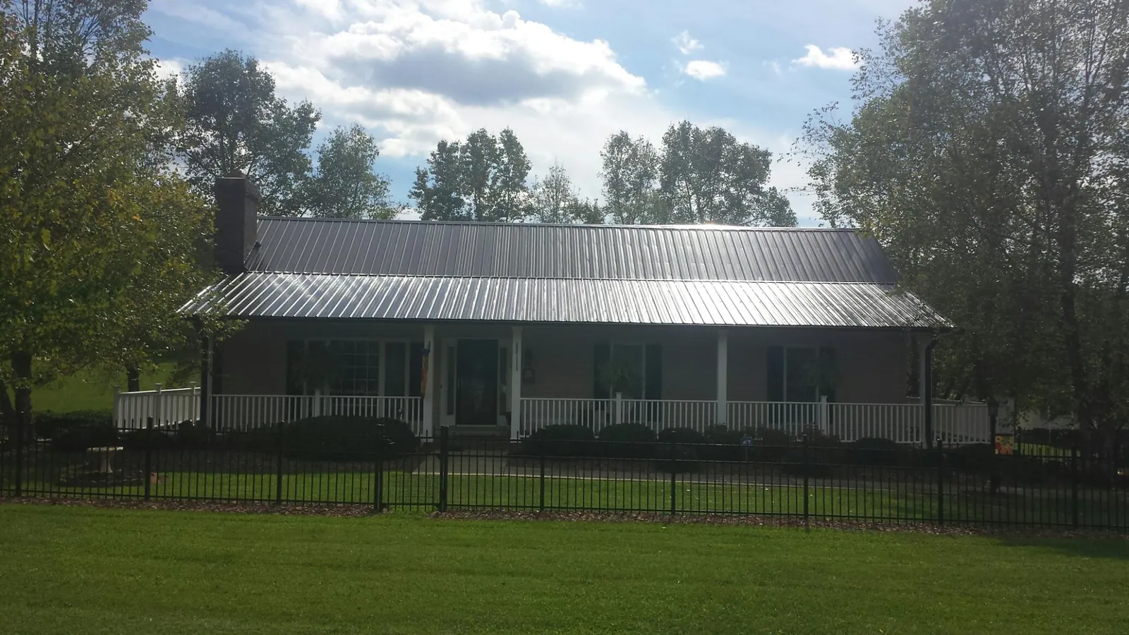 Gray metal roof on a brick ranch with a full width front porch — Gutter Guard Installation work by our crew in South Lake Tahoe